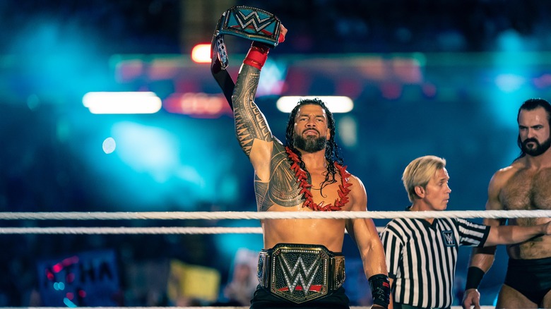 Roman Reigns raises the title