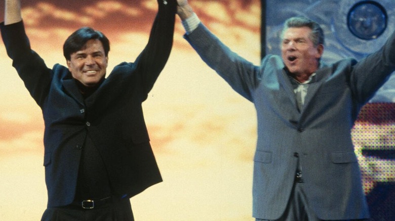 Vince McMahon holds up the arm of Eric Bischoff