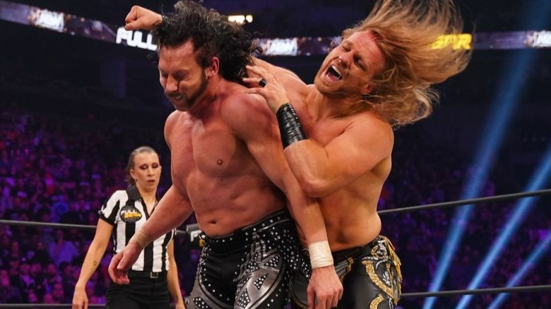 Adam Page striking Kenny Omega from behind