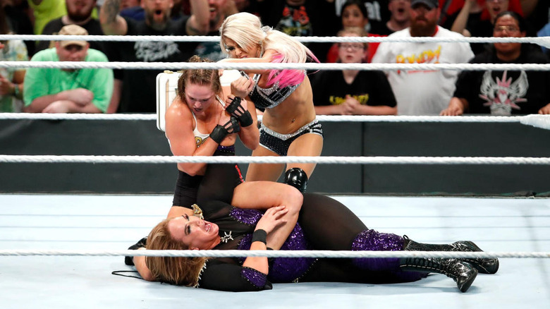 Alexa Bliss hitting Ronda Rousey with briefcase
