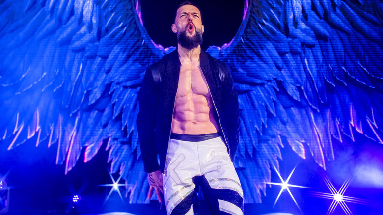 Finn Balor flexes in front of spread wings from his titantron.