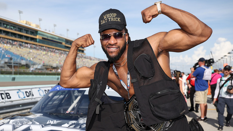 Trick Williams flexing in front of a race car