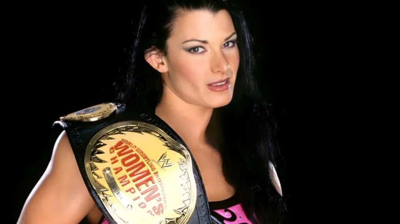 Former WWE Diva Victoria poses with the Women's Championship across her shoulder during a backstage photoshoot.