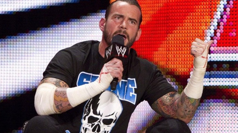 CM Punk sits cross legged on the WWE stage