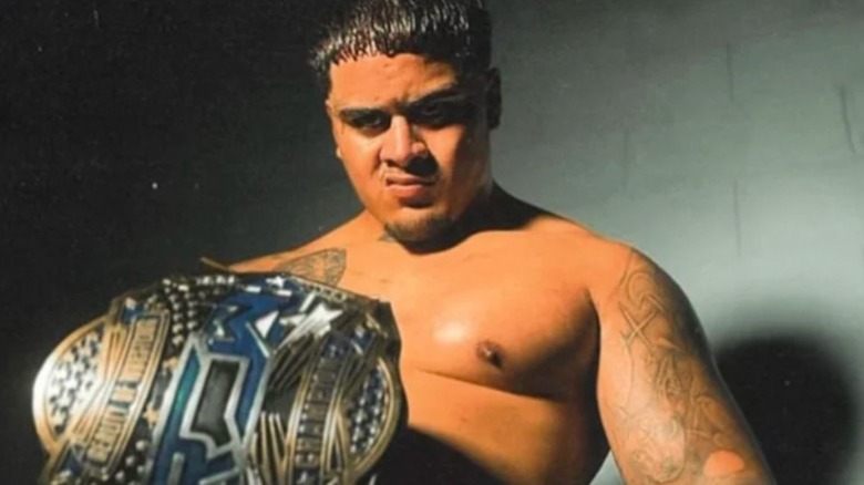 Zilla Fatu poses for a camera holding the ROW Championship