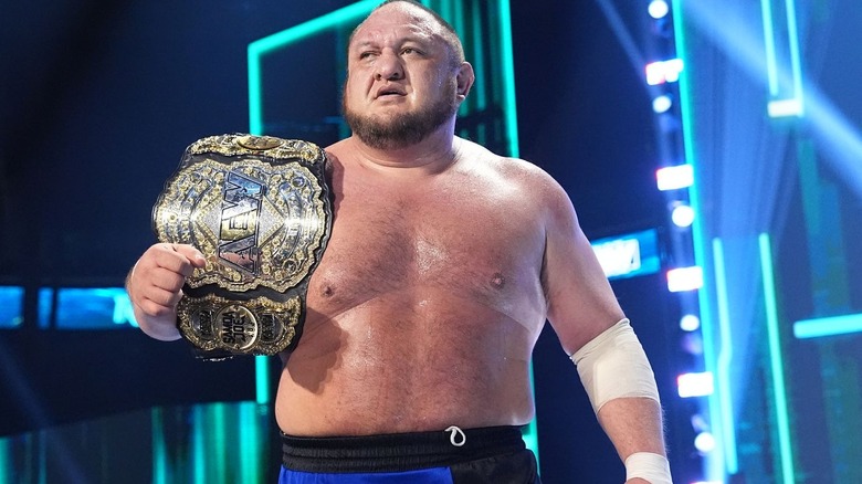 Samoa Joe with title belt over his shoulder