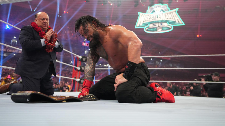 Roman Reigns and Paul Heyman kneeling in the ring