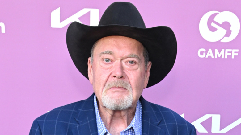 Jim Ross in front of a light purple background