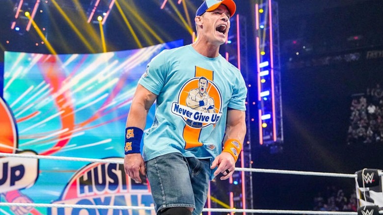 John Cena stands in the ring during his entrance for an appearance on an episode of WWE TV.