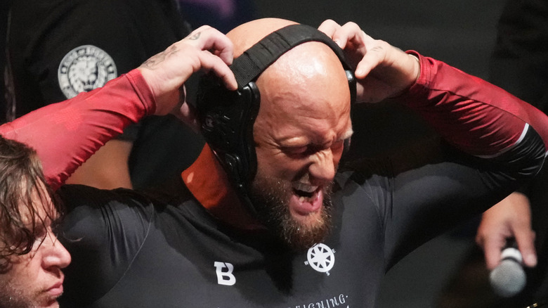 Josh Alexander grabbing his wrestling helmet