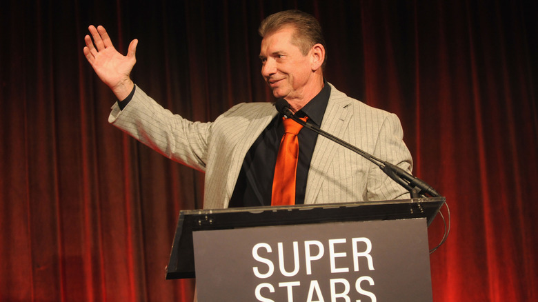 Vince McMahon raises hand