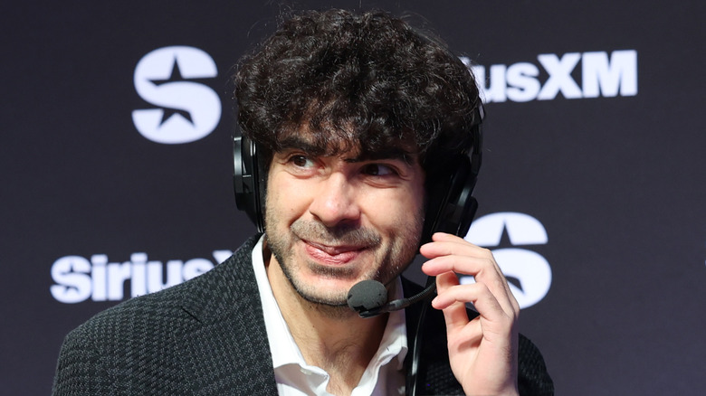 Tony Khan grinning while on headset