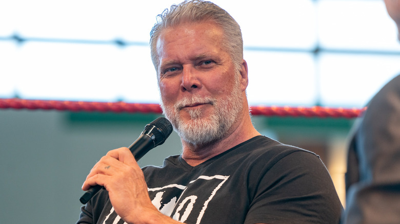 Kevin Nash is holding a microphone