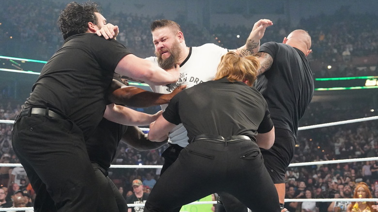 Kevin Owens being held back by security