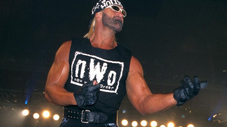 Hulk Hogan poses in the ring, wearing black and white nWo gear, before a match in WCW.