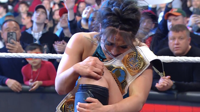 Lyra Valkyria clutches her knee as she cradles the Women's Intercontinental Championship.