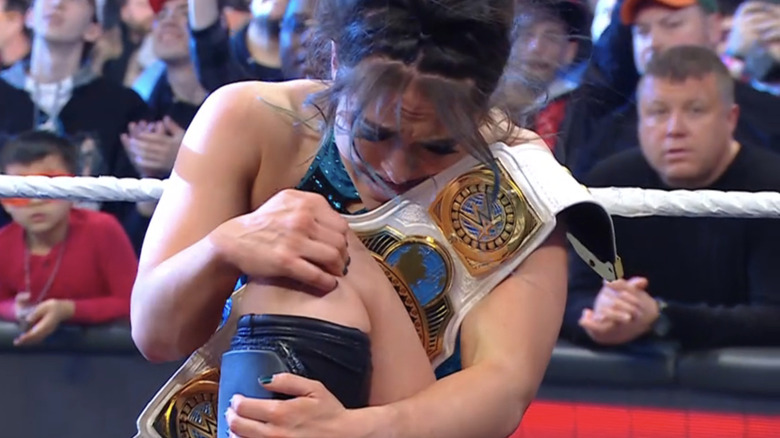 Lyra Valkyria clutches her knee as she cradles the Women's Intercontinental Championship.