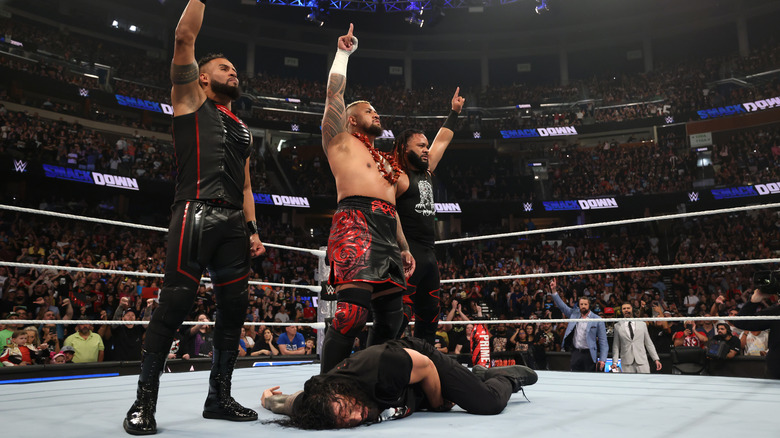 Tama Tonga, Solo Sikoa and Jacob Fatu stand over Roman Reigns