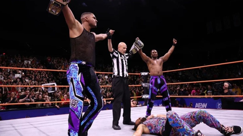 A referee holds up the hands of Quen and Zay after they defeated The Young Bucks for the AEW Tag Team Championships.