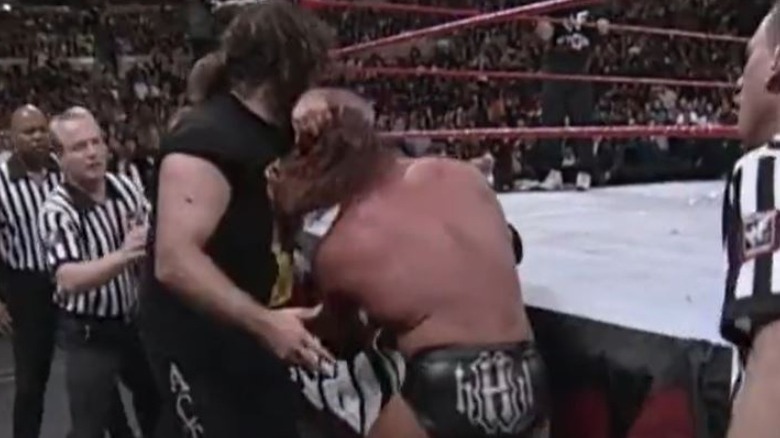 Mick Foley throws Triple H back into ring