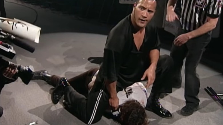 the rock holds mic to mick foley