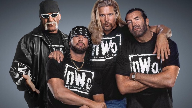 The New World Order, Hulk Hogan, Sean Waltman, Kevin Nash, and Scott Hall, pose in their nWo shirts for a backstage photo in WWE.