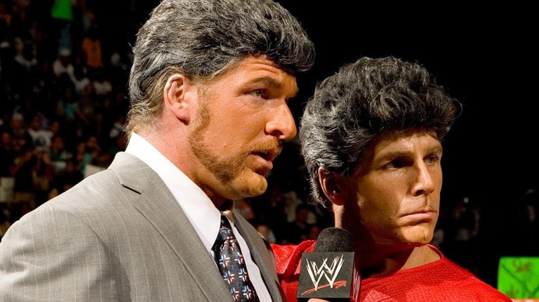 Triple H and Shawn Michael pose in the ring, dressed in wigs to impersonate Vince and Shane McMahon on an episode of "WWE Raw."