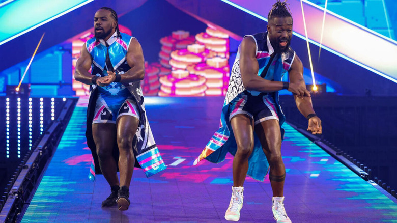 The New Day walk down the ramp of WrestleMania 38 in matching blue, pink, and black gear.