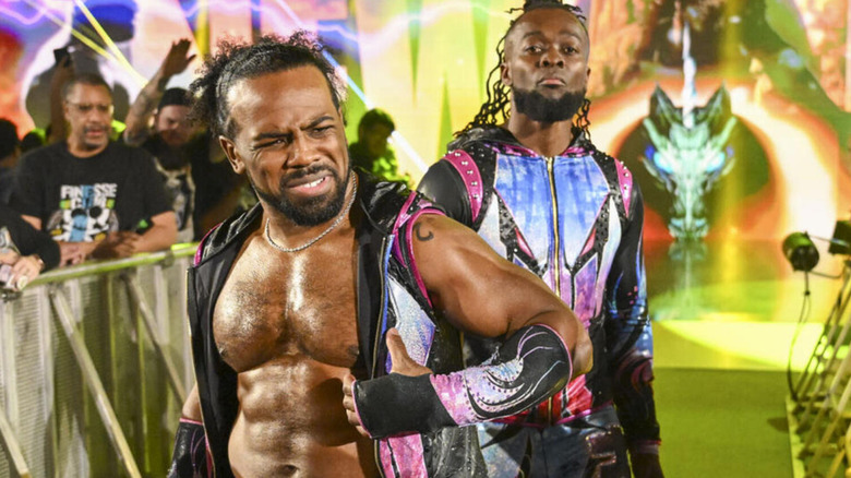 Xavier Woods and Kofi Kingston make their new entranced, bathed in green, orange, and yellow light.