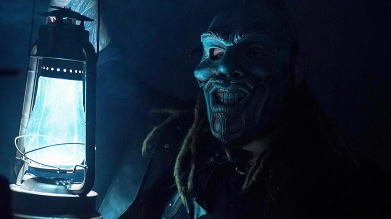 Bray Wyatt wearing mask and holding lantern