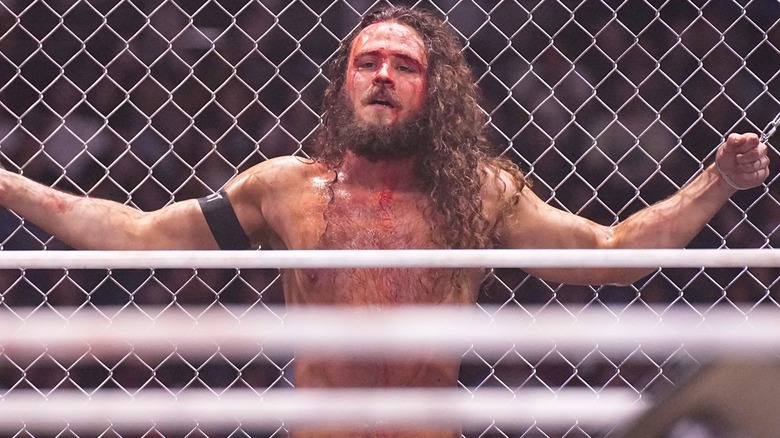 Jack Perry chained to a steel cage