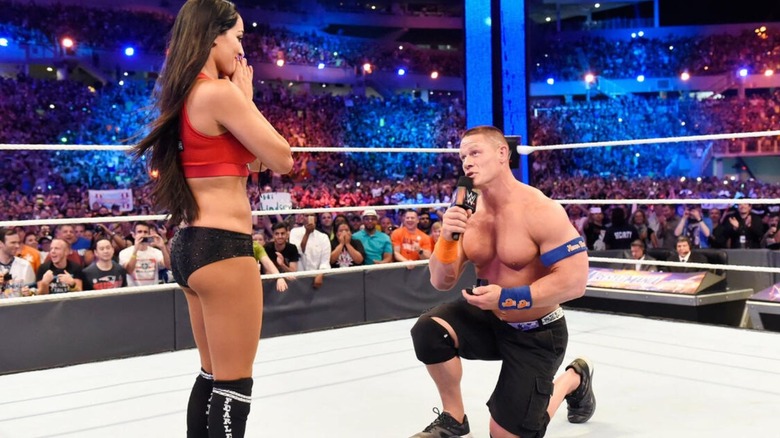 John Cena se arrodilla para proponerle matrimonio a Nikki Bella en el ring después de su victoria en WrestleMania contra The Miz y Maryse.