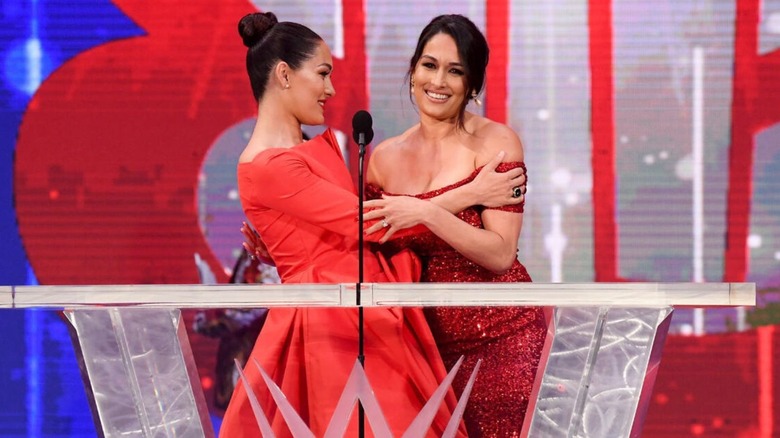 Nikka and Brie Bella embrace on the stage during the WWE Hall of Fame induction.