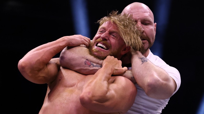 Orange Cassidy being choked by Jon Moxley