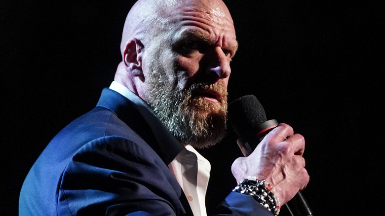 Triple H speaking into a microphone.