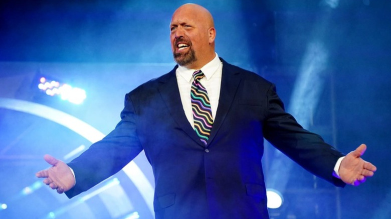 Paul Wight wearing a navy colored suit
