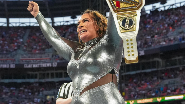 Nia Jax holds her hands up as she wins the WWE Women's Championship.