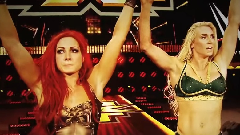 Becky Lynch and Charlotte Flair standing victorious