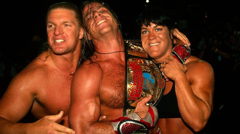 Triple H and Chyna huge Intercontinental Champion Shawn Michaels backstage following a match.