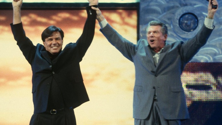 Vince McMahon raises Eric Bischoff's hand as the former is announced as the new general manager of "WWE Raw."