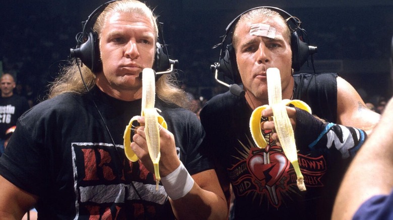 Triple H and Shawn Michaels hold up bananas while wearing commentary headsets on an episode of "WWE Monday Night Raw."