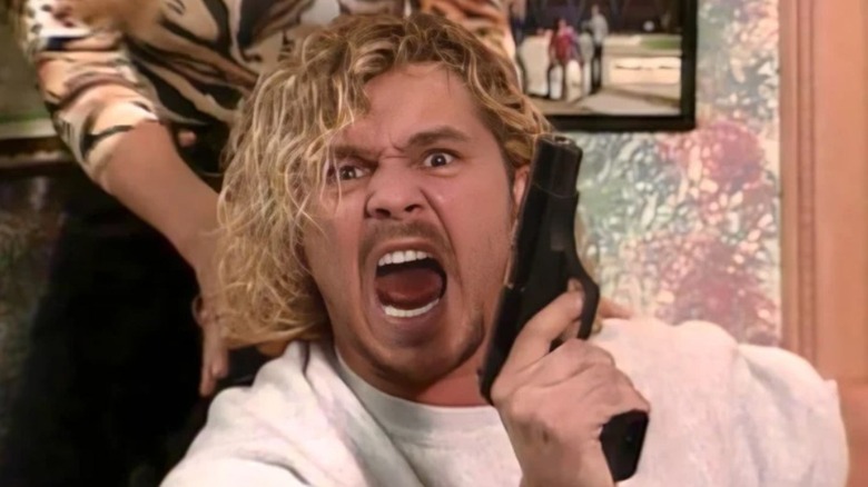 Brian Pillman brandishes a gun to the camera during an episode of WWE TV.