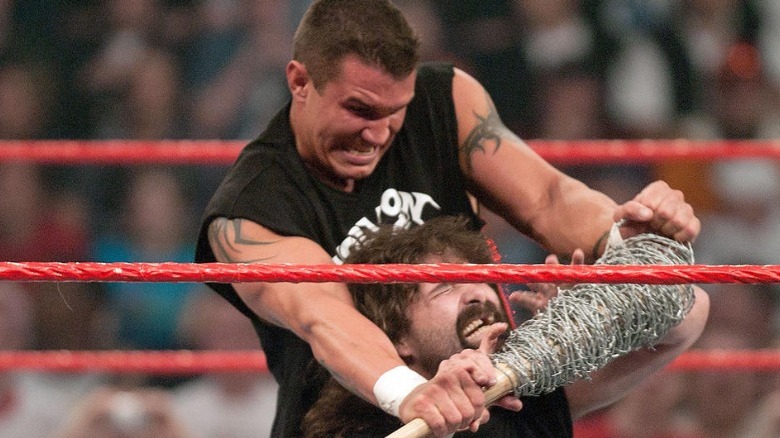 Randy Orton attacks Mick Foley with a barbe wire-wrapped bat