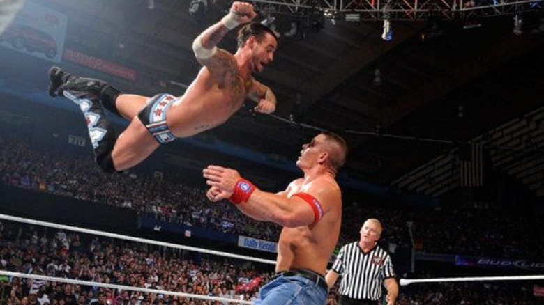 CM Punk dives  at John Cena