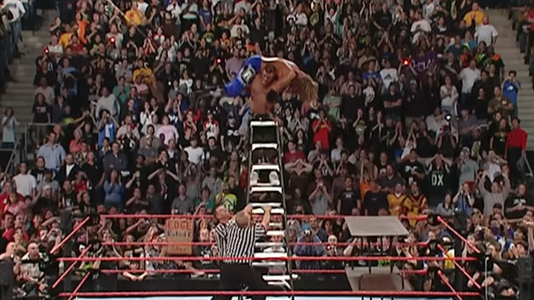 John Cena throws Edge off a ladder through a table