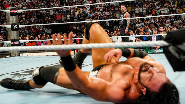 CM Punk with Drew McIntyre lying in the ring in the foreground