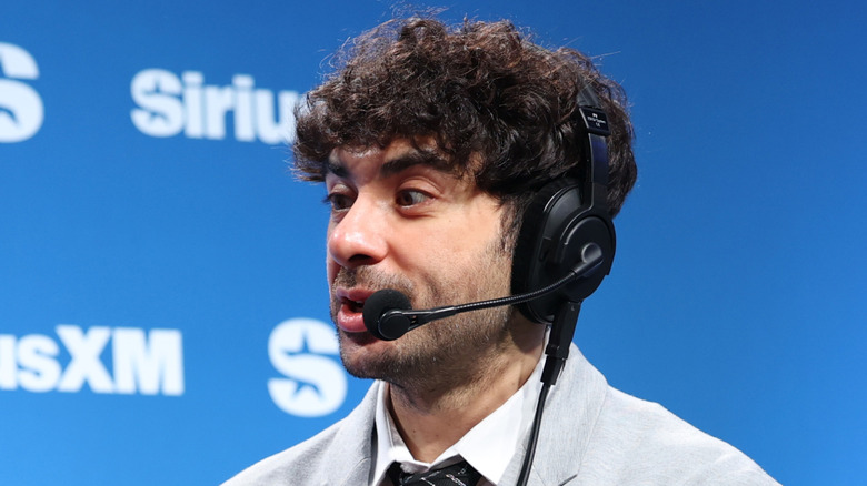 Tony Khan wearing a headset in front of a SiriusXM banner