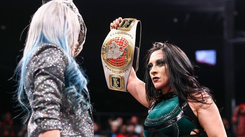 NXT Women's North American Champion Stephanie Vaquer holds up her championship to NXT Women's Champion Giulia in the middle of the ring.