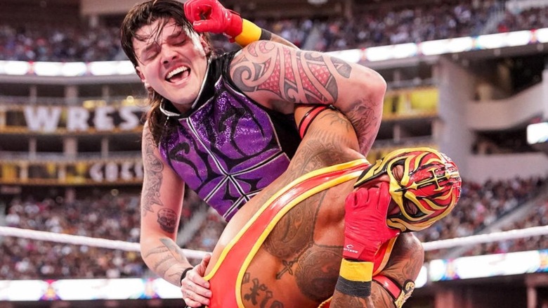 Dominik Mysterio puts his father, WWE Hall of Famer Rey Mysterio, in a submission maneuver in the middle of the ring during a WrestleMania match.