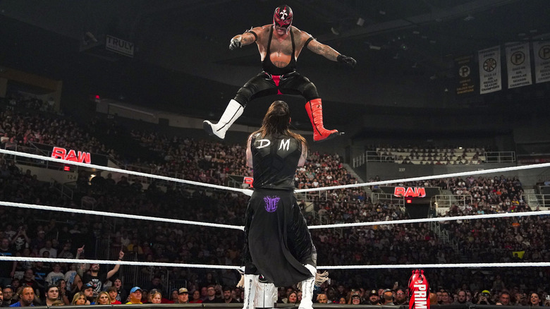 Rey Mysterio leaping onto Dominik Mysterio